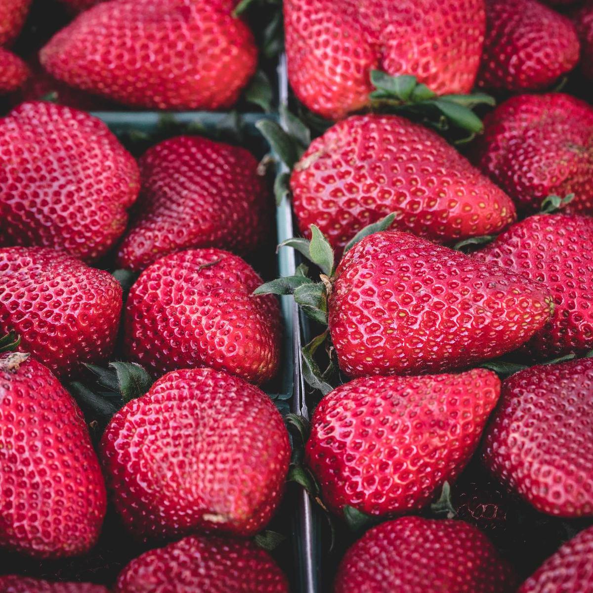 A crate of strawberries at a market stall.